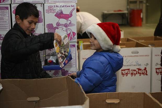 Twelve-year-old Nestor Villeda and 8-year-old Diego Villeda choose Christmas gifts for a child on Wednesday at Toys for Tots.