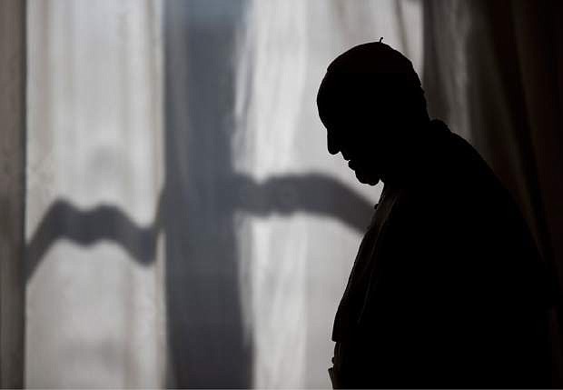 Pope Francis is silhouetted as he leaves after his meeting with Prime Minister of Albania Edi Rama and his wife Linda, at the Vatican, Thursday, April 24, 2014. (AP Photo/Alessandra Tarantino, Pool)