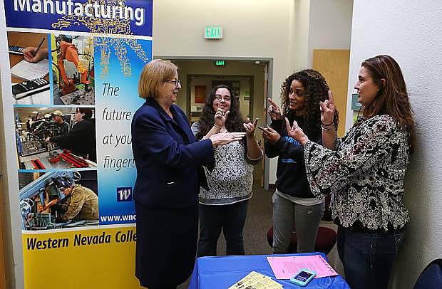 Career and Technical Education Director Georgia White, left, gets a lesson from American Sign Language students Lyssa Goldsworthy, Sierra Shaw and Mary Smith during the Career and Technical Education Open House at Western Nevada College on Oct. 20, 2016.