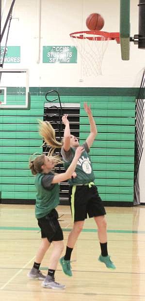 Hannah Evans shoots a basket as Hannah Hitchcock prepares for the rebound during a warmup drill in a Lady Wave practice.