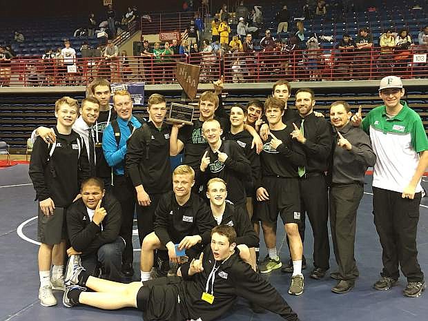 The Wave varsity wrestling team poses with the state championship trophy Saturday night in Primm.