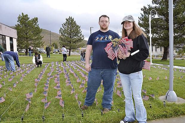 Josh Patterson and Ruby Herman place flags for Veteran Suicide Awareness Walk Saturday at the Western Nevada College campus.