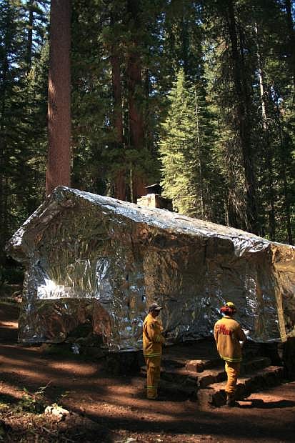 In this photo provided by the National Park Service, a Merced Grove cabin, next to the giant sequoias, is covered in metal foil by CalFire crews trying to protect structures from the Rim Fire burning through trees near Yosemite National Park, Calif., on Tuesday, Aug. 27, 2013. Firefighters gained some ground Tuesday against the huge wildfire burning forest lands in the western Sierra Nevada, including parts of Yosemite National Park. (AP Photo/National Park Service)