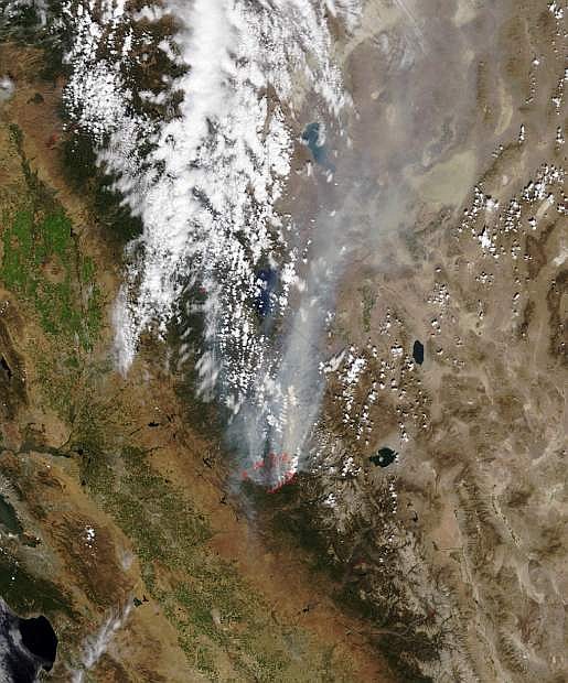 In this Monday, Aug. 26, 2013 satellite photo released by NASA, a smoke plume trails north from the drought-fueled Rim Fire, center, burning near Yosemite National Park in central California. Red outlines indicate hot spots where the satellite detected unusually warm surface temperatures associated with fires. Containment of the fire more than doubled to 15 percent, although it was within a mile of the park&#039;s Hetch Hetchy Reservoir, the source of San Francisco&#039;s famously pure drinking water, officials said. (AP Photo/NASA)