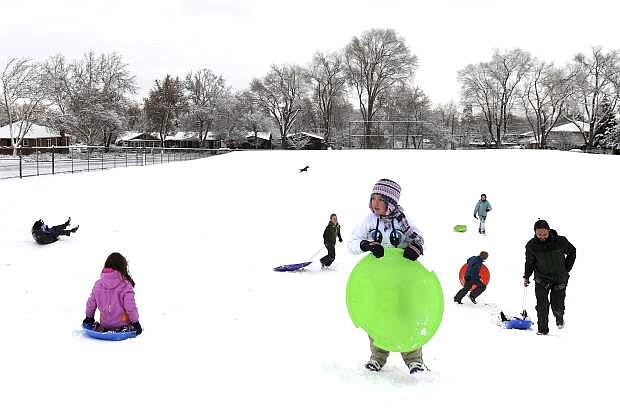 People enjoy sledding in Plumas Park, Thursday, Jan. 5, 2017, in Reno, Nev. A winter storm has swept aside two long-standing snow records in Boise, Idaho, and is moving east as turbulent weather lined up across much of the country Thursday with watches covering large parts of the South. (Jason Bean/The Reno Gazette-Journal via AP)