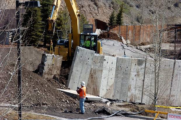 A work crew moves a concrete barrier that failed to stop a slow-motion landslide in Jackson, Wyo., as houses and businesses in the slide zone remained at risk on Saturday, April 19, 2014. No one can say when the mountainside collapsing into this Wyoming resort town will give way. But it appears increasingly likely that when it does, it&#039;s going to take a piece of Jackson with it. (AP Photo/Matthew Brown)