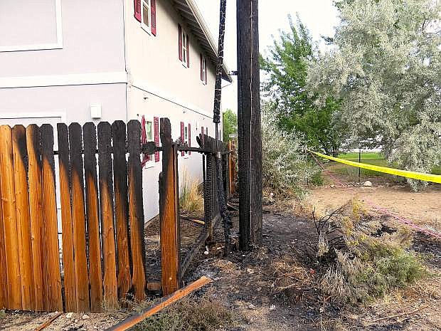 A fence and a power pole show signs where they were burned early Sunday morning.