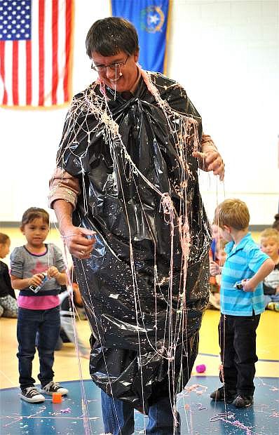 Northside Early Learning Center Principal John Johnson lets students get the wiggles out, letting them Silly String him. In the background are Alison Telles-Gutierrez, left, and Atticus Mayer. Treasa Pursley&#039;s class won the General Mills Box Top funding competition.