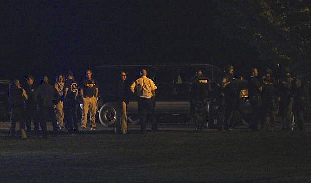 Law enforcement officers congregate in Heritage Park near Chichester Estates Tuesday night in Gardnerville.