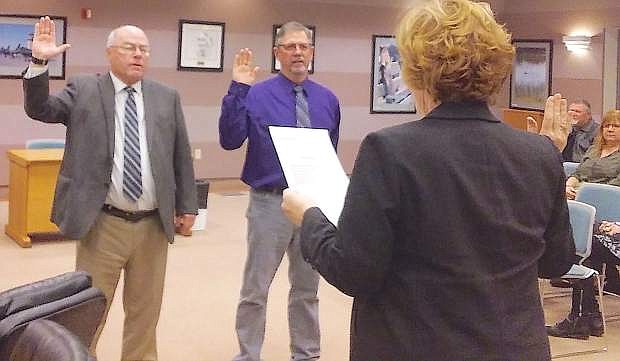 County Clerk/Treasurer Kelly Helton swears in county commissioners Bus Scharmann, left, and Carl Erquiaga.