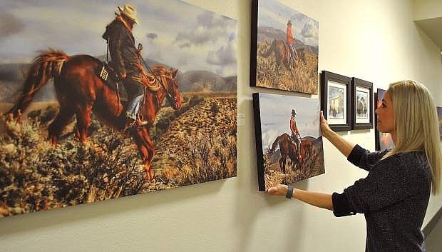 Churchill County&#039;s Julie Guerrero hangs work by photographer Dennis Doyle for the upcoming open house. Self-taught with 20 years&#039; experience, local artist Doyle captures images throughout the west.