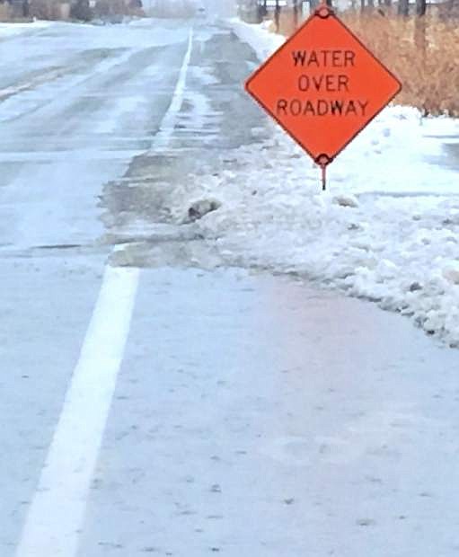 Signs indicate water on the roadway on Cottonwood Lane and in the Fernley Farm District.