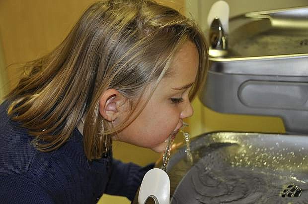 A Nevada elementary school student takes a drink from a school fountain.