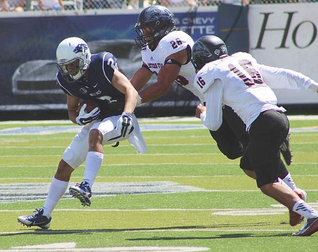 Southern Utah&#039;s Toa Afatasi (26) and Josh Smith (16) stop Nevada&#039;s Richy Turner (2) after he picks up several yars in the first half of Saturday&#039;s season opener for the Wolf Pack.