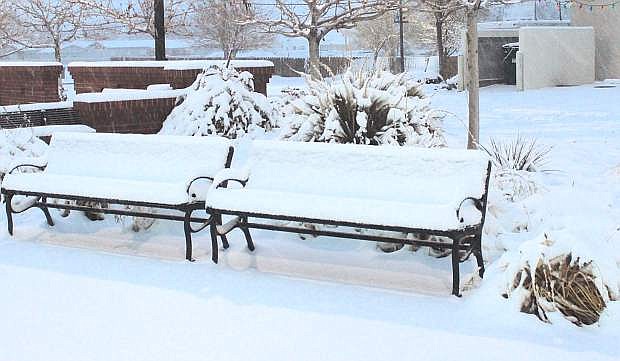 Snow covers a bench at Millennium Park.