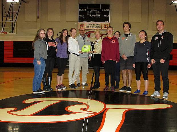 Douglas High officials and athletes join Kitty McKay of Carson Tahoe Health athletic program in the high school gym on Thursday.