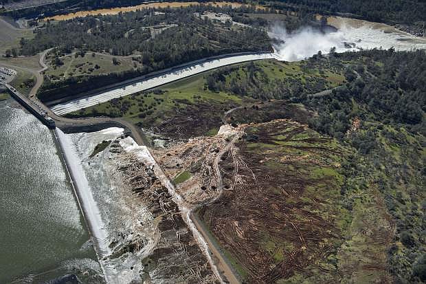 Lake water flows over the emergency spillway, bottom left, at Lake Oroville for the first time in the nearly 50-year history of the Oroville Dam Saturday, Feb. 11, 2017, in Oroville, Calif. The dam opened in 1968. (Randy Pench/The Sacramento Bee via AP)