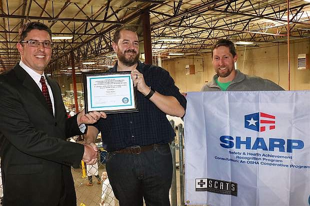 From left, Chief Administrative Officer of the Safety Consultation and Training Section, Todd Schultz, hands program certifications to Nature&#039;s Bakery Environmental Health and Safety Manager Gary Daniels, and Plant Manager Eric Reid at the Carson City facility Monday.