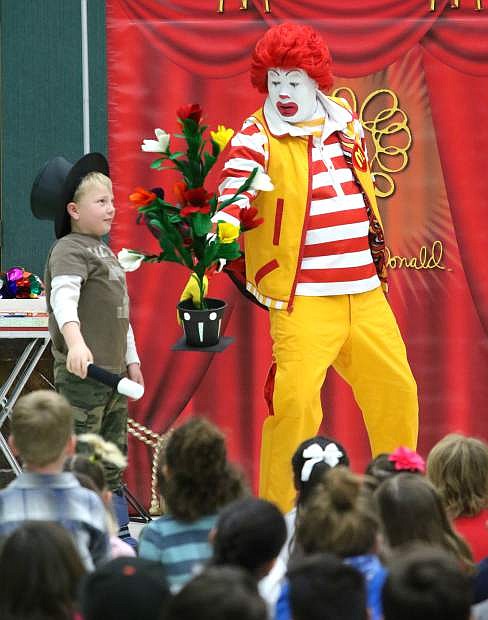 Bordewich Bray Elementary student Gabe Turiczek, 6, performs a magic trick with Ronald McDonald during a reading week kick-off assembly on Monday.