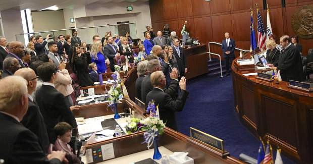 Chief Justice of the Nevada Supreme Court Michael Cherry, far right, gives the oath of office to Senate members on Monday.