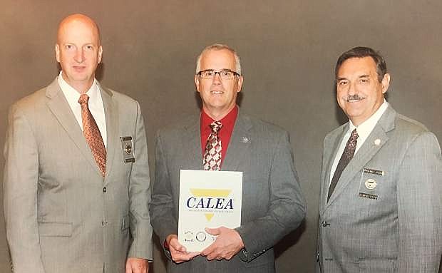 CALEA Commissioner Richard Myers, left, and Executive Director Craig Hartley, right, recognize Fallon Police Chief Kevin Gehman and the Fallon Police Department for achieving reaccreditation in meeting law enforcement standards.