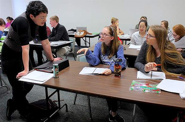 Oasis Academy Jump Start senior Kaitlin Haddock, left, and junior Ellie Gehman discuss story analysis with Western Nevada College English professor Jessica Rowe in her English 102 class.