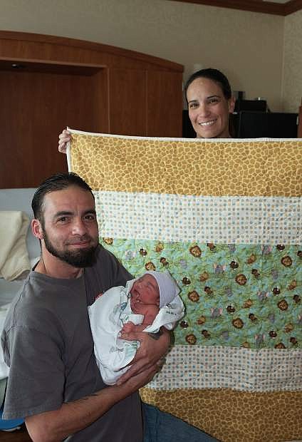 Paul Aguilera and Karen Holbert with their new baby, Bow, born on National Quilting Day. The Carson Valley Quilt Guild made a quilt which was presented to the family along with other gifts.