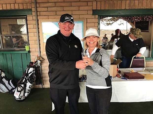 Marty Davis presents an award, an engraved glass, to Amy Matzen for hitting the ball the closest to the hole during the &quot;meet the pro&quot; tournament.