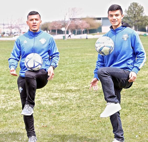 Christian and Guillermo Hernandez show off their dribbling skills on a windy day at Mills Park Thursday.