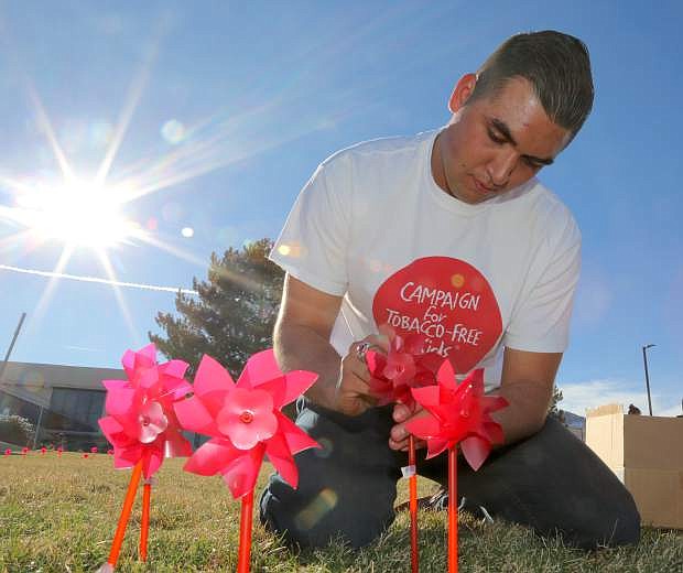 Western Nevada College student and &quot;Kick Butts Day&quot; event coordinator Spencer Flanders sticks pinwheels into the front lawn of the campus on Tuesday afternnon.