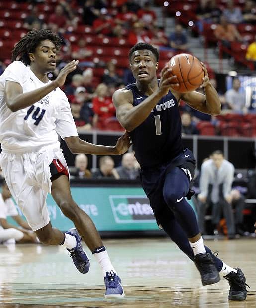 Utah State&#039;s Koby McEwen drives to the hoop as Nevada&#039;s Lindsey Drew defends during the second half Thursday.