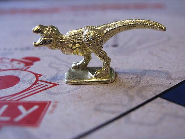 This March 15, 2017 photo shows the T-Rex dinosaur, one of three new tokens that will be included in upcoming versions of the board game Monopoly, in Atlantic City, N.J. Hasbro Inc. revealed the results of voting on Friday, March 17, 2017. Leaving the game will be the boot, wheelbarrow and thimble tokens. (AP Photo/Wayne Parry)