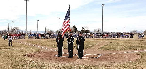 The Fallon Youth Baseball teams line up behind the color guard for the national anthem.