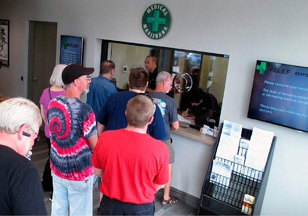 FILE - In this July 31, 2015, file photo, people line up to be among the first in Nevada to legally purchase medical marijuana at the Silver State Relief dispensary in Sparks, Nev. Nevada still plans to launch recreational marijuana sales in July, 2017, despite warnings this week of a federal crackdown by the administration of President Donald Trump. (AP Photo/Scott Sonner, File)