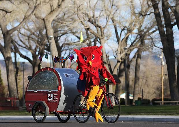 Oprah the Owl, the mascot of the Carson City Library, rides the Pedal Library around Mills Park in Carson City, Nev., on Friday, March 31 2017. The trailer, provided by the Friends of the Carson City Library and other community partners, will allow the library to take their services to events around the community. The public is invited to an unveiling Monday at noon at the Capitol. Photo by Cathleen Allison/Nevada Photo Source