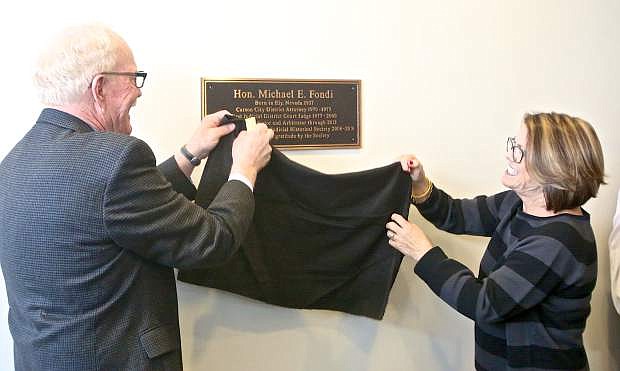 Judge Tom Perkins (left) and Judge Michael Fondi&#039;s wife of 24 years, Val Cooney, unveil a plaque placed in his honor Friday at the Carson City Courthouse.