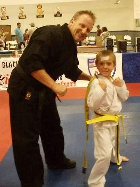 Blake Glidewell, 7, son of Kristin Hendricks, advances to his next belt level with No Limits instructor and owner, Shawn Goodner.