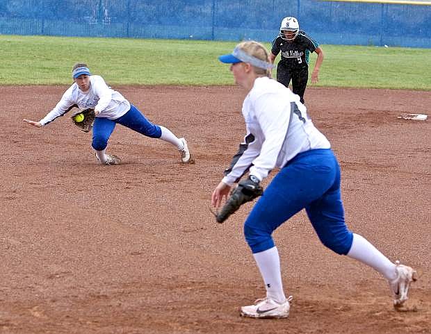 Shortstop Bella Kordonowy makes a diving catch while third baseman Faith Bigelow moves to cover her base Thursday in a game agains North Valleys.