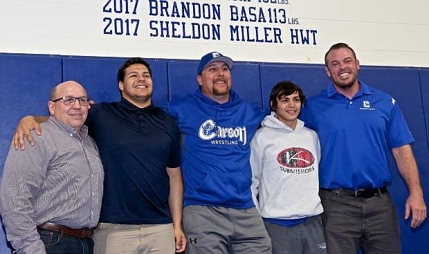 State Champions Sheldon Miller and Brandon Basa pose for a photo with CHS Wrestling coaches Keith Shaffer (left), Nick Redwine (center) and Clint Treadway (right) Thursday at Carson High.