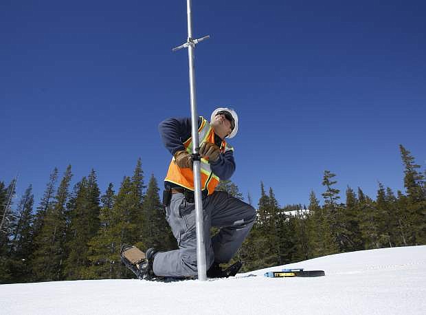 FILE- In this April 3, 2017, file photo, Tony Orozco, an hydrographer for the Pacific Gas &amp; Electric pushes the snow survey tube into the snowpack during a PG&amp;E snow survey near Spaulding Lake in Nevada County, Calif. State snowpack surveyors head out Monday, May 1, for the final manual measurement of the wet season. (AP Photo/Rich Pedroncelli, File)