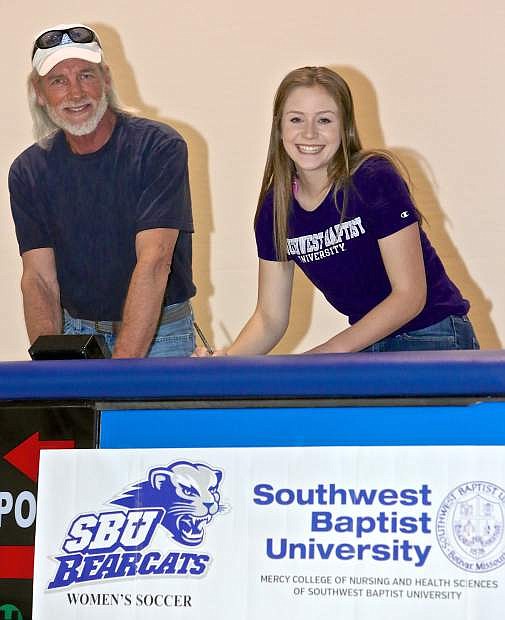 CHS senior Lauren Hudak, along with her father Kyle, signs her letter of intent to play soccer at Southwestern Baptist University in Missouri Thursday at Carson High.
