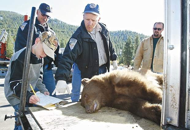 NDOW biologist Carl Lackey, pictured here with his son Nolan, is suing the Homewood-based Bear League and several individuals for comments made online that he claims have damaged his reputation and caused him emotional distress.