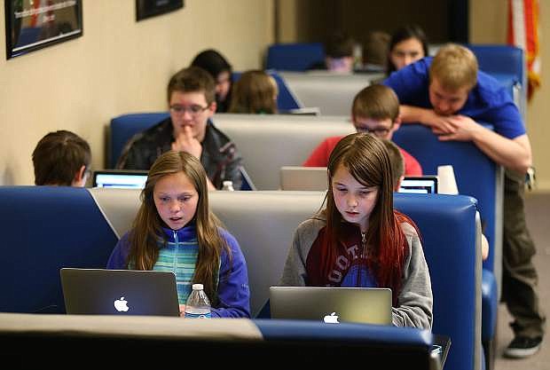 Reese MacKenzie, left, and Tarah Wright, both 11, learn coding and 3D-modeling at a camp at the Carson City Library in Carson City, Nev., on Tuesday, March 29, 2016. Tprogram is among many that are in danger of being eliminated under proposed federal cuts.program is among many that are in danger of being eliminated under proposed federal cuts. The programs is among many that are in danger of being eliminated under proposed federal cuts.