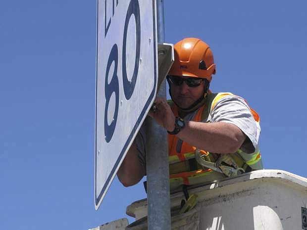 Tim Furlong, a signage supervisor for the Nevada Department of Transportation, puts the finishing touches on a new 80 mph speed limit sign posted along U.S. Interstate 80 Monday, May 8, 2017, near Fernley, Nev., about 40 miles east of Reno. Nevada joins South Dakota, Wyoming, Montana, Idaho, Utah and Texas as the only states that now allow speeds in excess of 75 mph on parts of rural highways and interstates. (AP Photo/Scott Sonner)