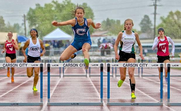 Sophomore Ashley Britt powers through a rainstorm to win the 300-meter hurdles event Saturday at the league regional qualifier meet at the Jim Frank Track and Field Complex.