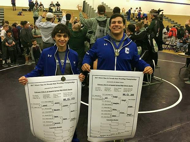 Brandon Basa and Sheldon Miller hold up their brackets from the state wrestling tournament.