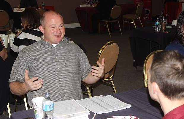 Matt Louie of Louie&#039;s Home Center answers a question for a prospective applicant at Friday&#039;s job fair.