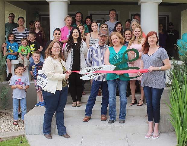 AmyJo Grissom (with scissors) and Brad Travis cut the ribbon with Amber Ayers, left, and Valerie Johnson, right, representing the Chamber of Commerce.