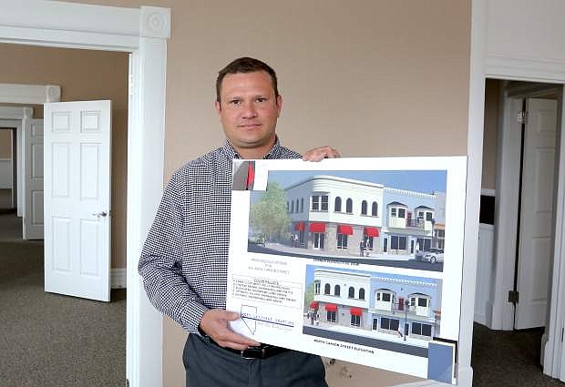 Samuel Douglass holds an artist rendering for the exterior of the Horseshoe building that has been remodeled into office space on the second floor.