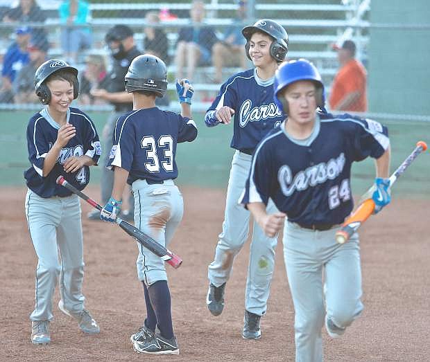 The Carson 12-year-old All-Stars congratulate each other at home plate after going up 7-0 over Reno Centennial in the first inning Wednesday night.